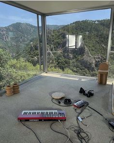 there are many electronic devices on the floor in front of a large window with mountains outside