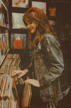 a woman looking at records in a record store