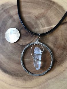 a piece of glass sitting on top of a wooden table next to a dime coin