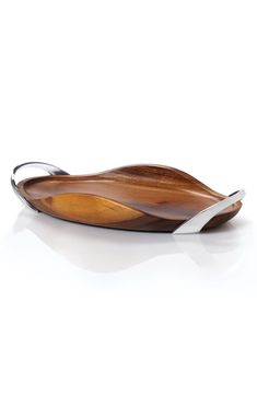 a wooden serving tray with metal handles and two curved sections on the bottom, sitting on a white surface