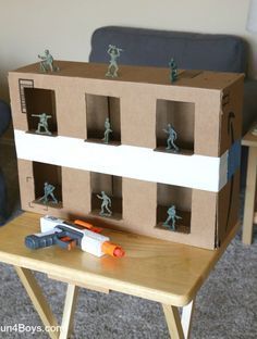 a cardboard house with toy soldiers on the front and sides, sitting on top of a small table