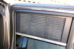 an old fashioned radio sitting in the back of a truck with its door open and it's screen missing