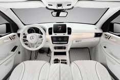 the interior of a car with all white leather and black trims, including steering wheel