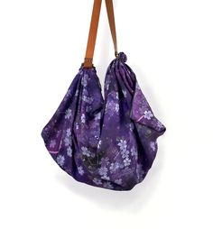 The Silk Takuyo Shoulder Carry All Tote Bags has the beautiful dark purple Cherry Blossom design. An ample sized Scarf shoulder Tote Bag comes with a vegan leather strap to tie a pretty large square scarf into a carry all unique bag. Simple instruction is included in the packaging. A traditional part of the Japanese way of life, furoshiki are squares of fabric used for carrying and storing things. They range in size, from a small handkerchief to a large bag. * Click the link below to see the mat Purple Pouch Shoulder Bag For Travel, Purple Hobo Bag For Travel, Purple Travel Hobo Bag, Purple Rectangular Hobo Bag With Adjustable Strap, Purple Shoulder Bag With Removable Pouch For Gift, Purple Hobo Bag With Removable Pouch For Daily Use, Purple Rectangular Hobo Bag For Travel, Purple Shoulder Bag With Leather Handles For Travel, Purple Leather-handled Crossbody Bag