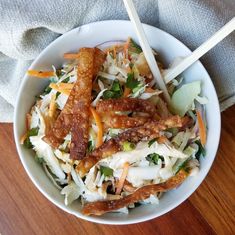 a white bowl filled with salad and chopsticks