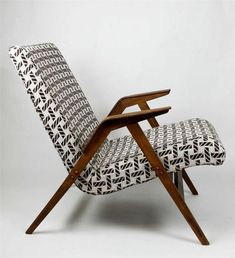 an upholstered chair with wooden legs and arm rests in front of a white background