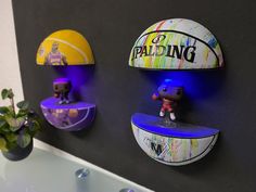 there are three wall mounted basketballs on the wall and one has a small figure