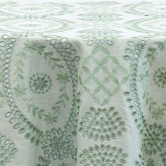 an image of a table cloth with flowers and circles on the top in shades of green