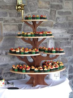 cupcakes are arranged in the shape of a tree on top of a table