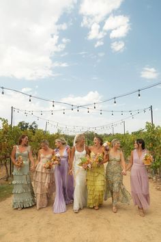 a group of women standing next to each other in front of a string of lights