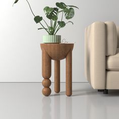 a small table with a potted plant on it next to a couch