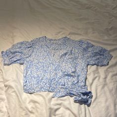 a blue and white shirt laying on top of a bed