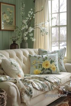 a white couch sitting next to a window covered in pillows