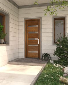 the front door to a house with plants and rocks on the ground in front of it