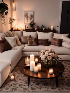 a living room filled with lots of furniture and candles on top of the coffee table