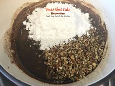 the ingredients are mixed together in a large bowl on the stove top, including brownies and white powder