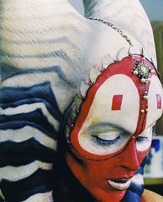 a woman with her face painted red and white