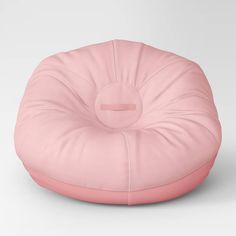 a pink bean bag chair sitting on top of a white floor