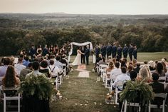 a couple getting married at the end of their wedding ceremony on top of a hill