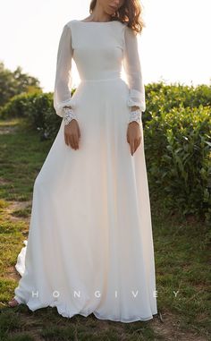 a woman wearing a white dress standing in the grass with her hands on her hips