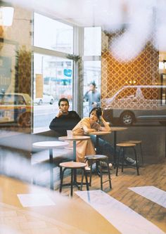 two people sitting at tables in a restaurant