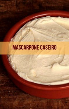 a red bowl filled with cream sitting on top of a wooden table next to a bottle of mascarpone cassero