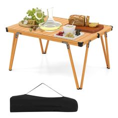 a wooden table with food on it and a black piece of luggage next to it