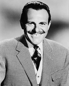 a black and white photo of a man in a suit with a moustache