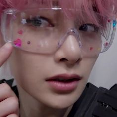 a person with pink hair wearing glasses