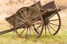 an old wooden wagon sitting in the grass