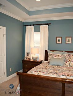 a bed room with a neatly made bed next to a window and a night stand