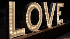 the word love is lit up with light bulbs