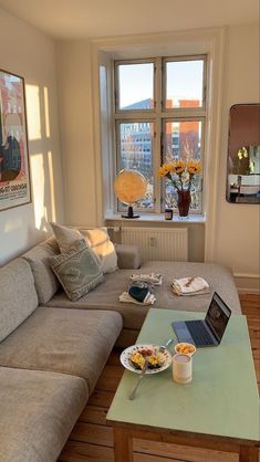 a living room filled with furniture and a laptop computer on top of a coffee table