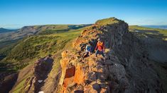 two people standing on the edge of a cliff