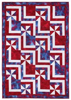 a red, white and blue quilt with stars in the center on top of it