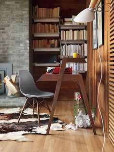 a room with a desk, chair and bookshelf