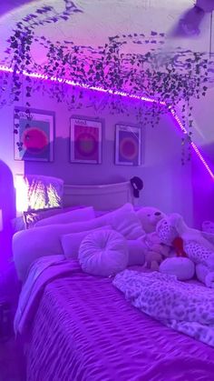 a bedroom with purple lighting and stuffed animals on the bed