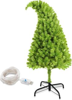 a small green christmas tree sitting on top of a table next to a white cord