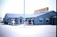 some people are standing outside of a restaurant