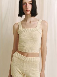 This product is a crop knit sleeveless top that offers a contemporary and cozy addition to any wardrobe with its textured fabric and cropped cut. The piece is designed for a snug fit that highlights the waist, making it an excellent partner to high-waisted bottoms. - The top features a delicate knit pattern that adds a touch of elegance to the simple silhouette.- Its cropped length is on-trend, perfect for pairing with various high-waisted garments.- The sleeveless design makes it ideal for layering under jackets or wearing alone in warmer weather.- Constructed with comfort in mind, the soft knit material provides a gentle feel against the skin. Fitted Cropped Beige Tank Top, Fitted Cropped Knit Sweater Vest, Cropped Knit Fitted Sweater Vest, Fitted Knit Tank Crop Top, Fitted Tank Knit Crop Top, Fitted Cropped Knit Tank Top, Fitted Cropped Sweater Vest For Summer, Chic Knit Tank Crop Top, Seamless Cropped Knit Tank Top