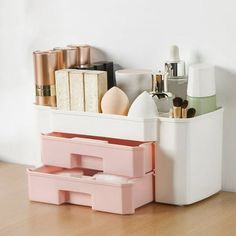 a white container filled with cosmetics on top of a wooden floor next to a wall