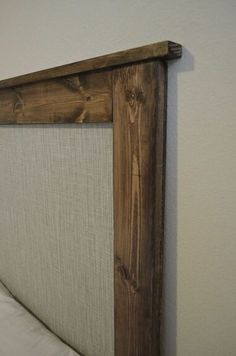 an upholstered headboard made out of wood and fabric with white linens