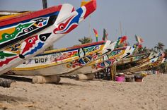 colorful boats are lined up on the beach