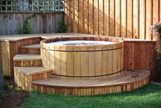 a wooden hot tub sitting in the middle of a yard