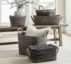 three woven baskets sitting on top of a table next to a vase with flowers in it