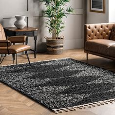 a living room with leather couches and a rug on the floor in front of a potted plant