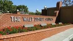 the entrance to the walt disney studios with flowers growing out of it's sides