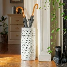 two umbrellas are placed in a white vase