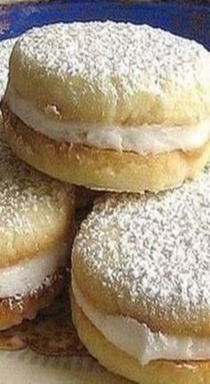 four donuts with frosting and powdered sugar on them sitting on a plate