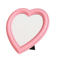 a pink heart shaped mirror sitting on top of a black stand